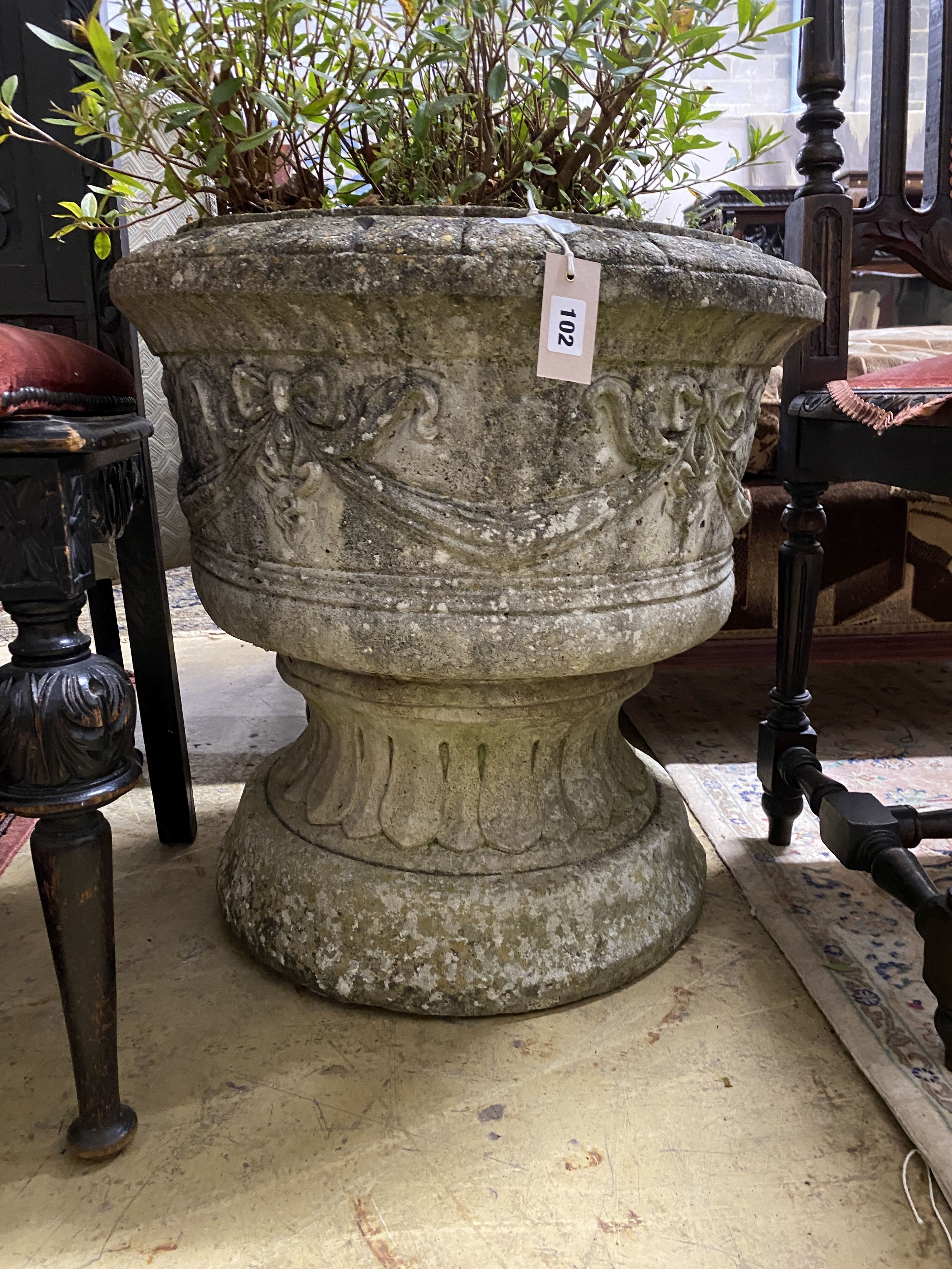 A circular reconstituted stone garden planter with ribbon fold moulded body, diameter 58cm, height 59cm